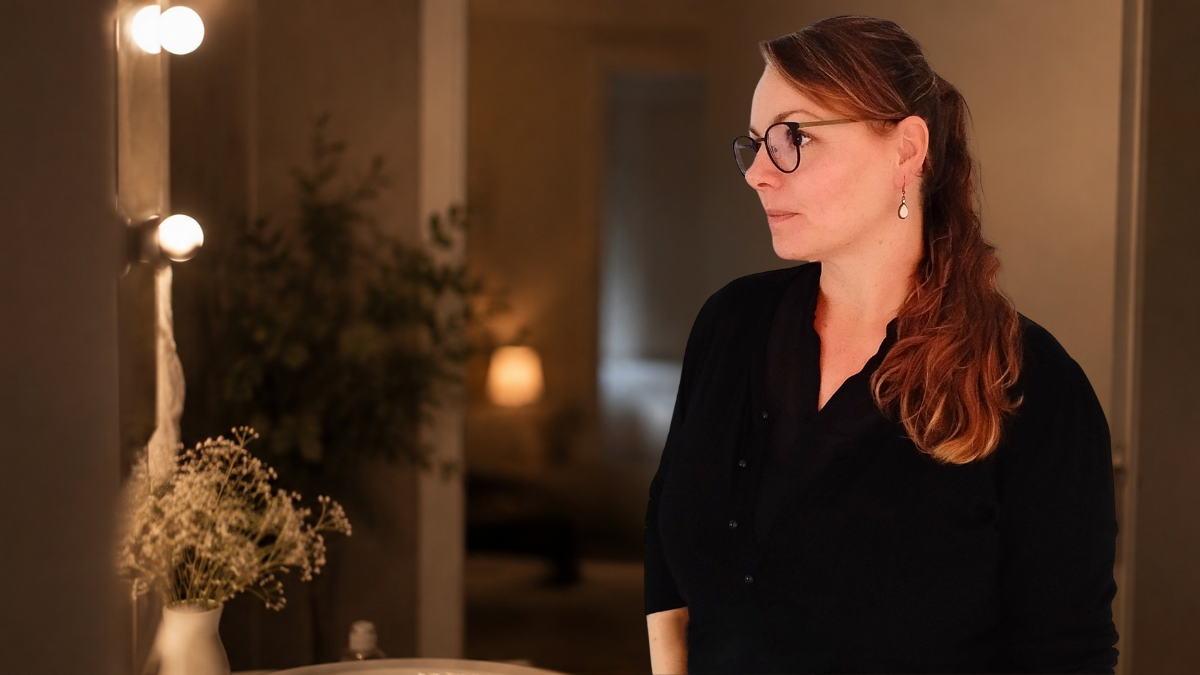 moment-hilfe-eingestehen Sabine steht abends nachdenklich vor dem Spiegel – der Moment, sich Hilfe einzugestehen